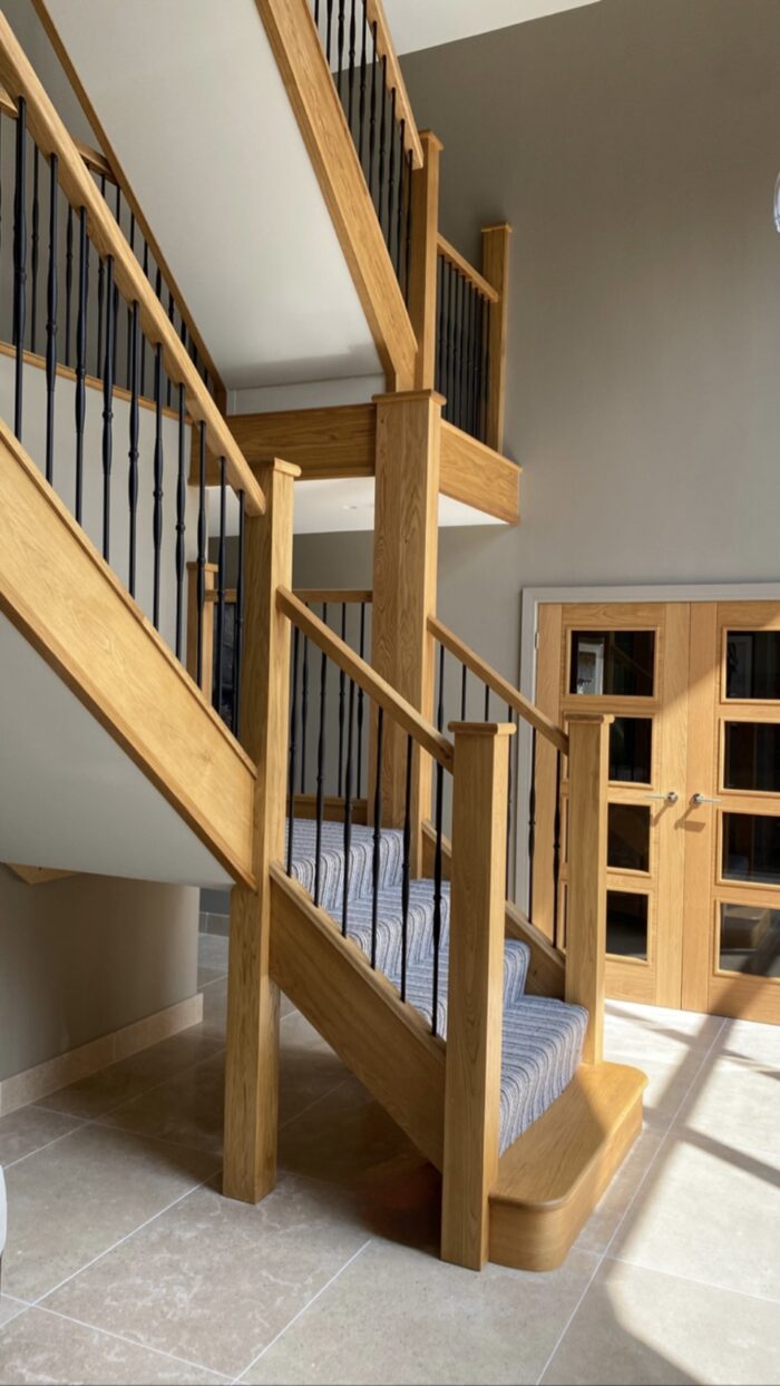 Oak handrail with black metal spindles on staircase