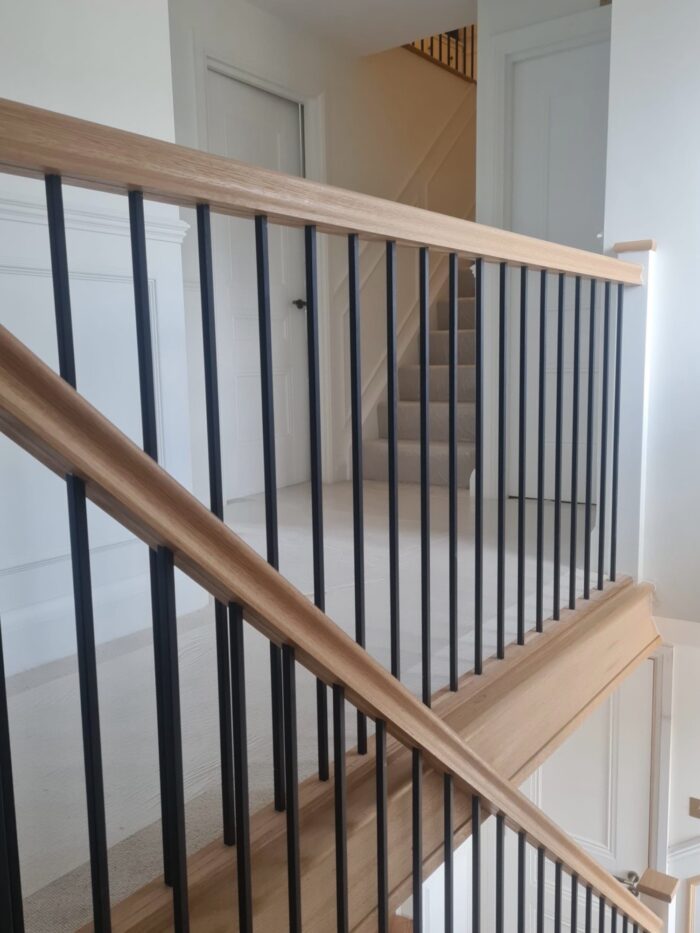 oak handrail and baserail with black metal round spindles