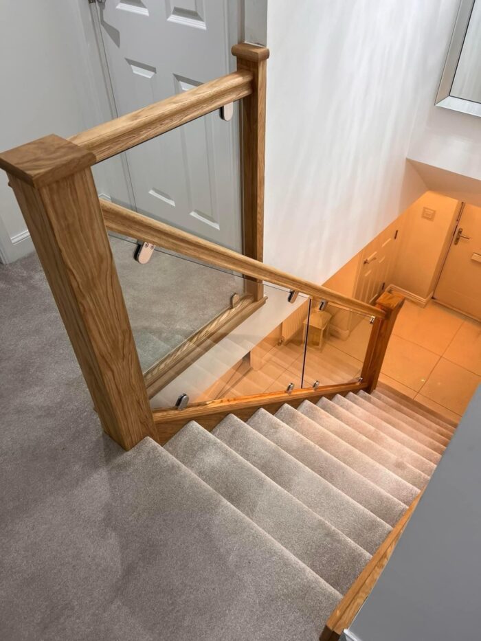 Oak staircase with glass panels and chrome metal glass clamps
